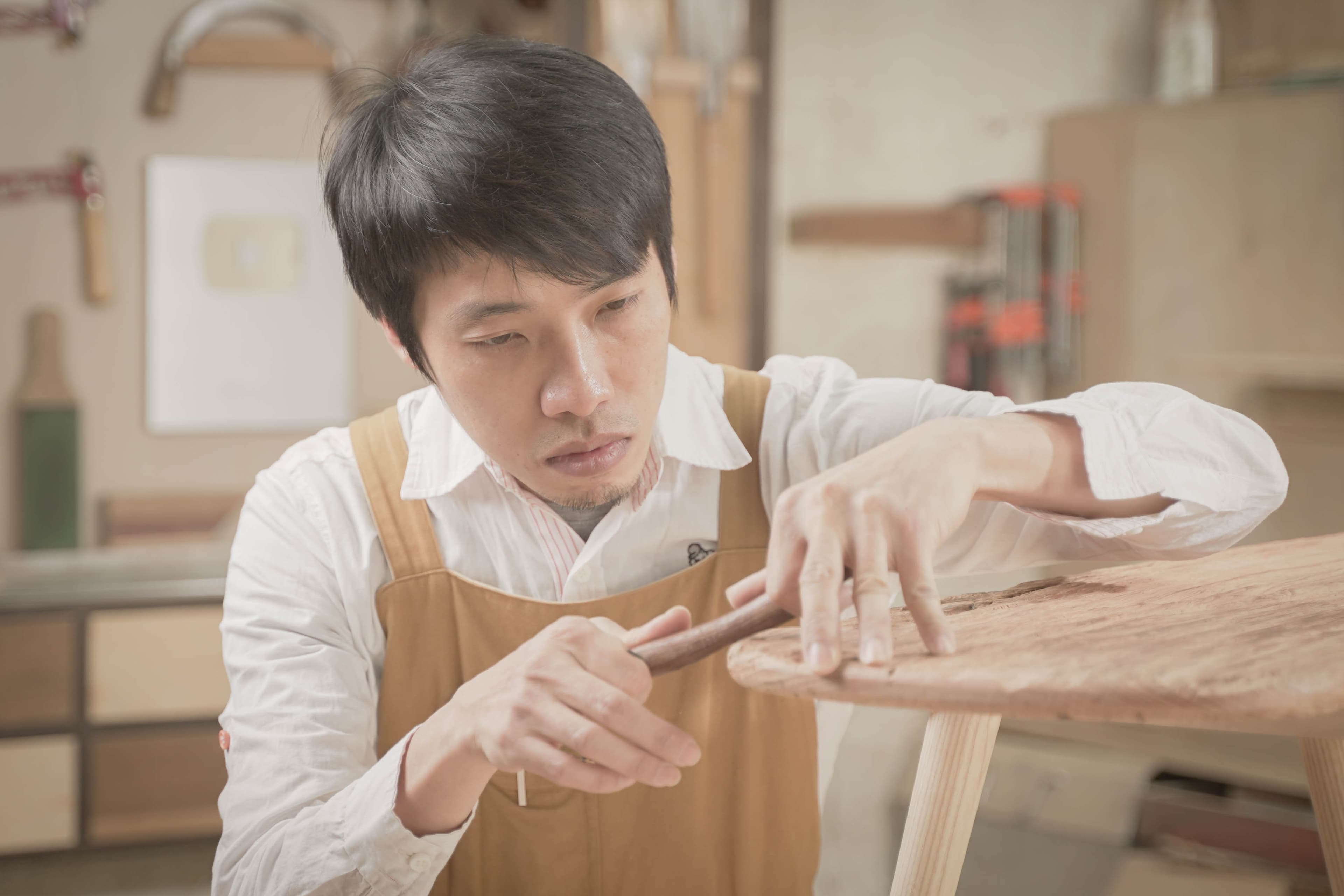 木頭仁在工作室專注修整圓凳